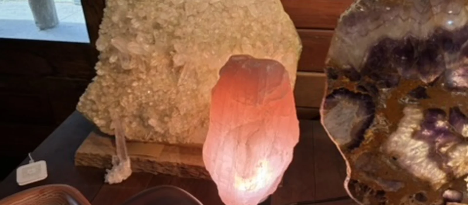 Mineral pieces, timber objects and a warm lamp displayed inside the gallery